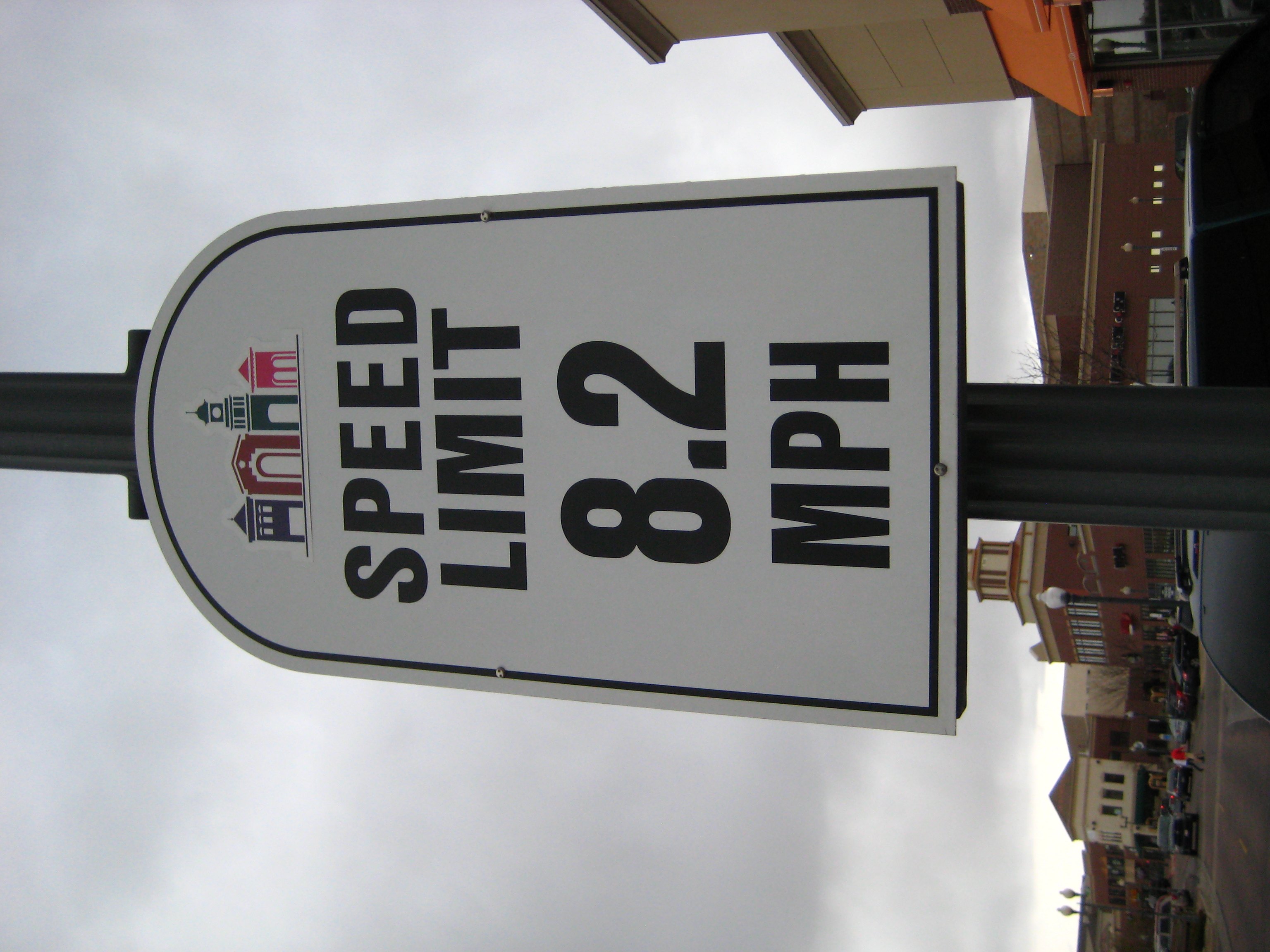 a speed limit sign with buildings in the background