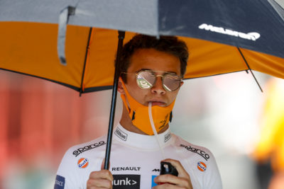 a man wearing sunglasses and a mask under an umbrella