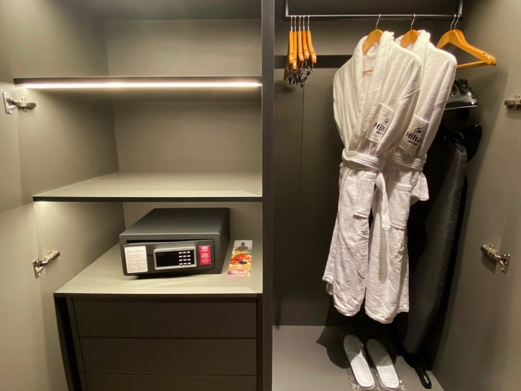 a closet with white robes and a safe