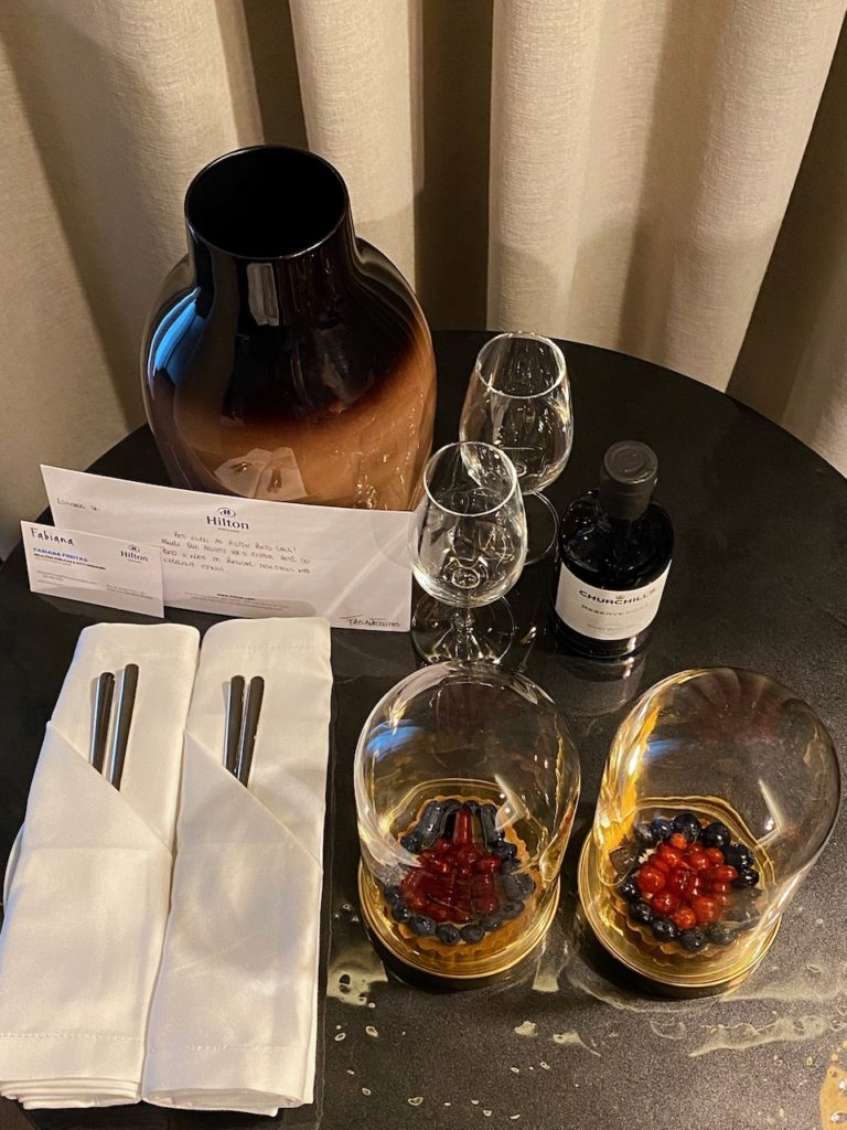 a table with glasses and a vase and a bottle