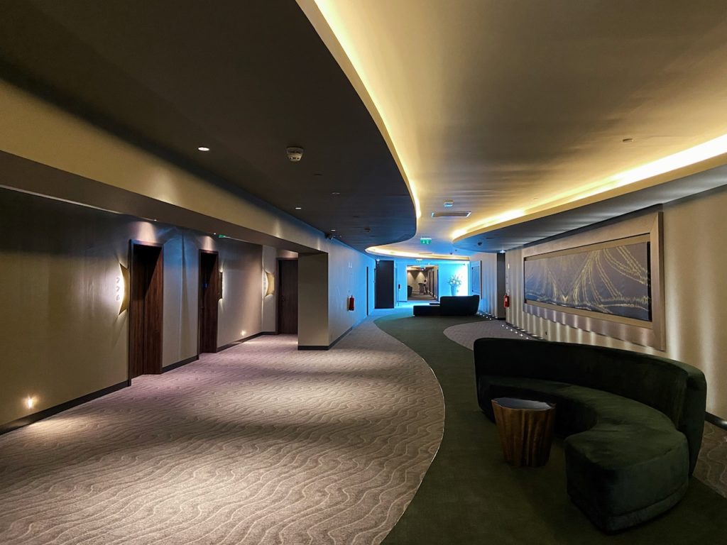 a long hallway with a curved couch and a television