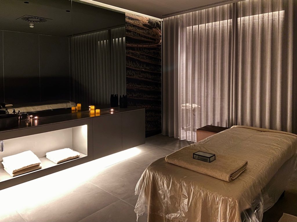 a massage room with a bed and a mirror